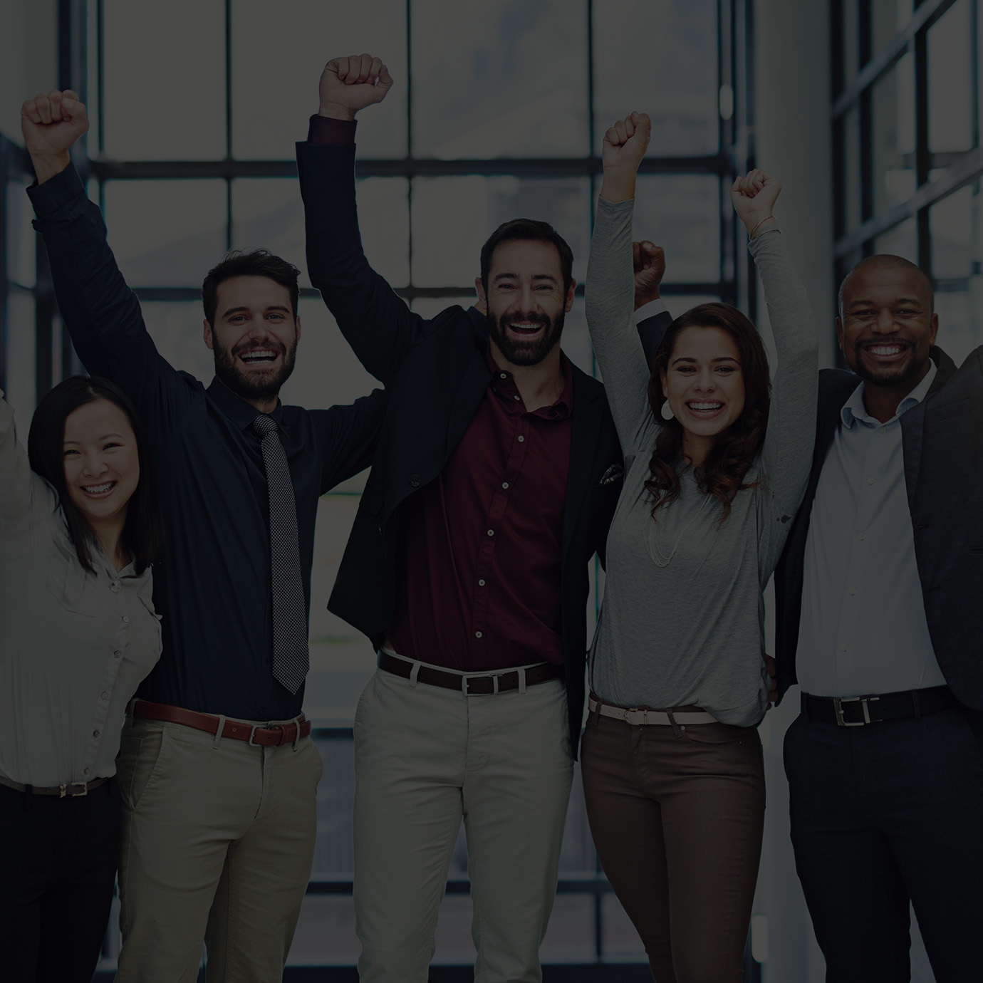 Five professionals standing together raising their arms to cheer 