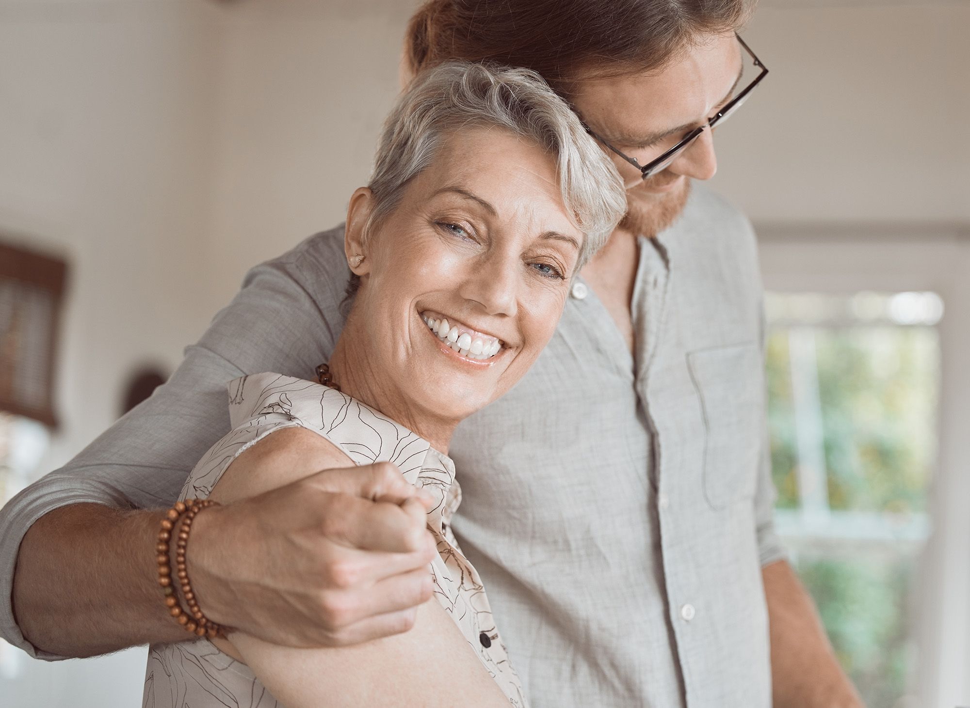 A senior lady hugged by her son