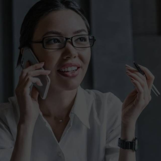 Young woman talking on a phone and holding a pen 