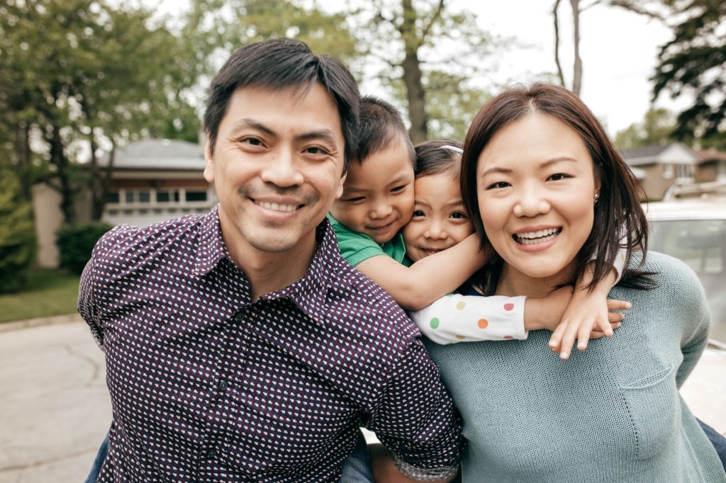 Parents and two kids behind them all smiling 