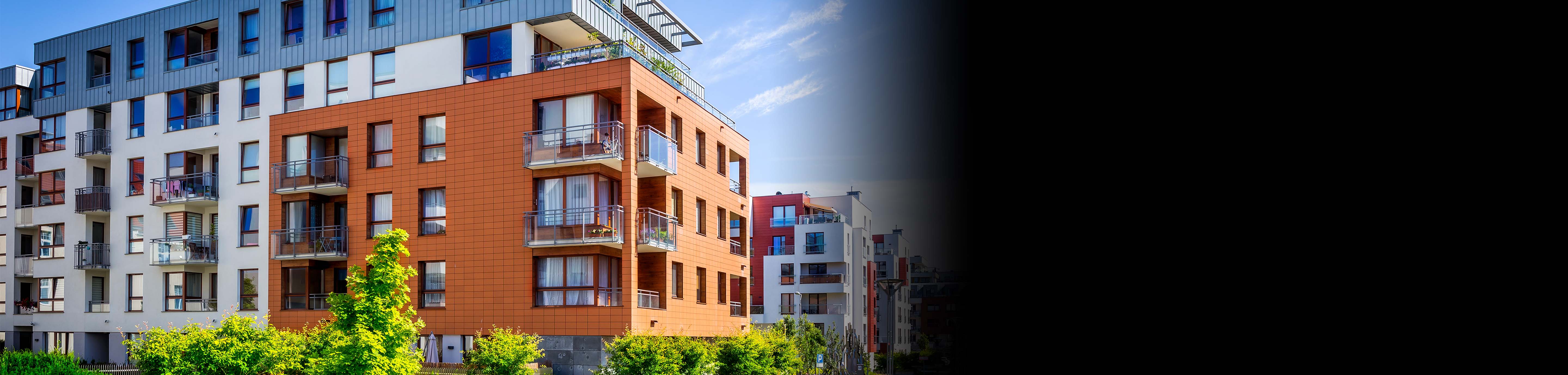 A low-rise condo building with trees around it