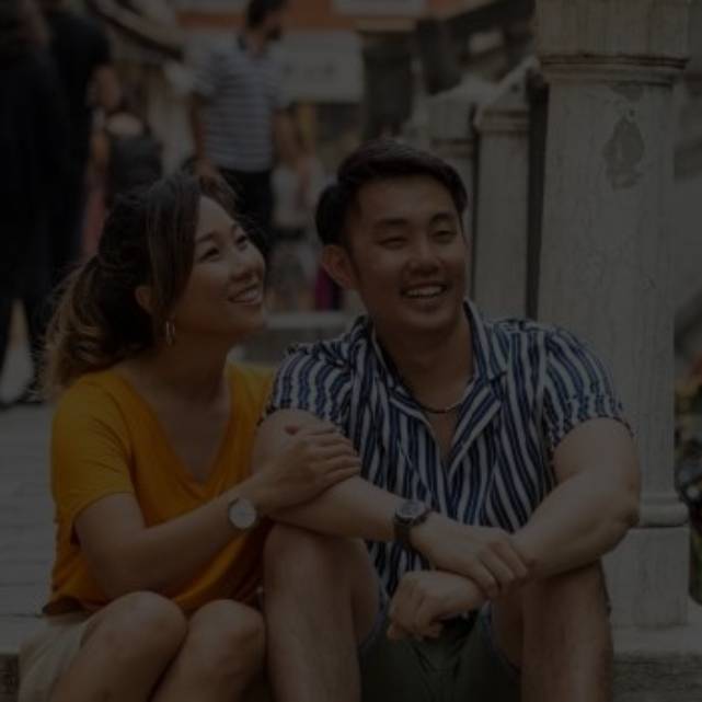 A young Asian couple sitting by the river with a lagoon on it