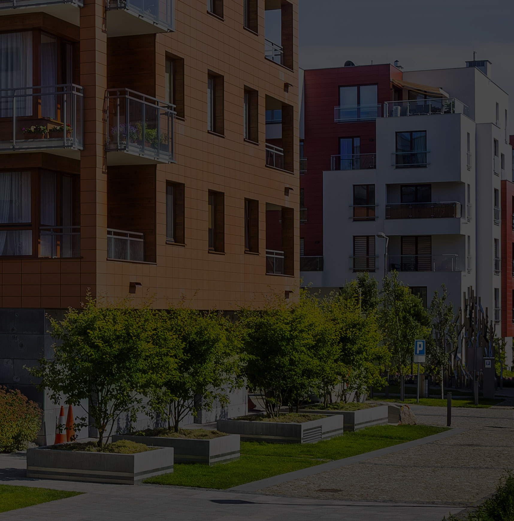 A low-rise condo building with trees around it