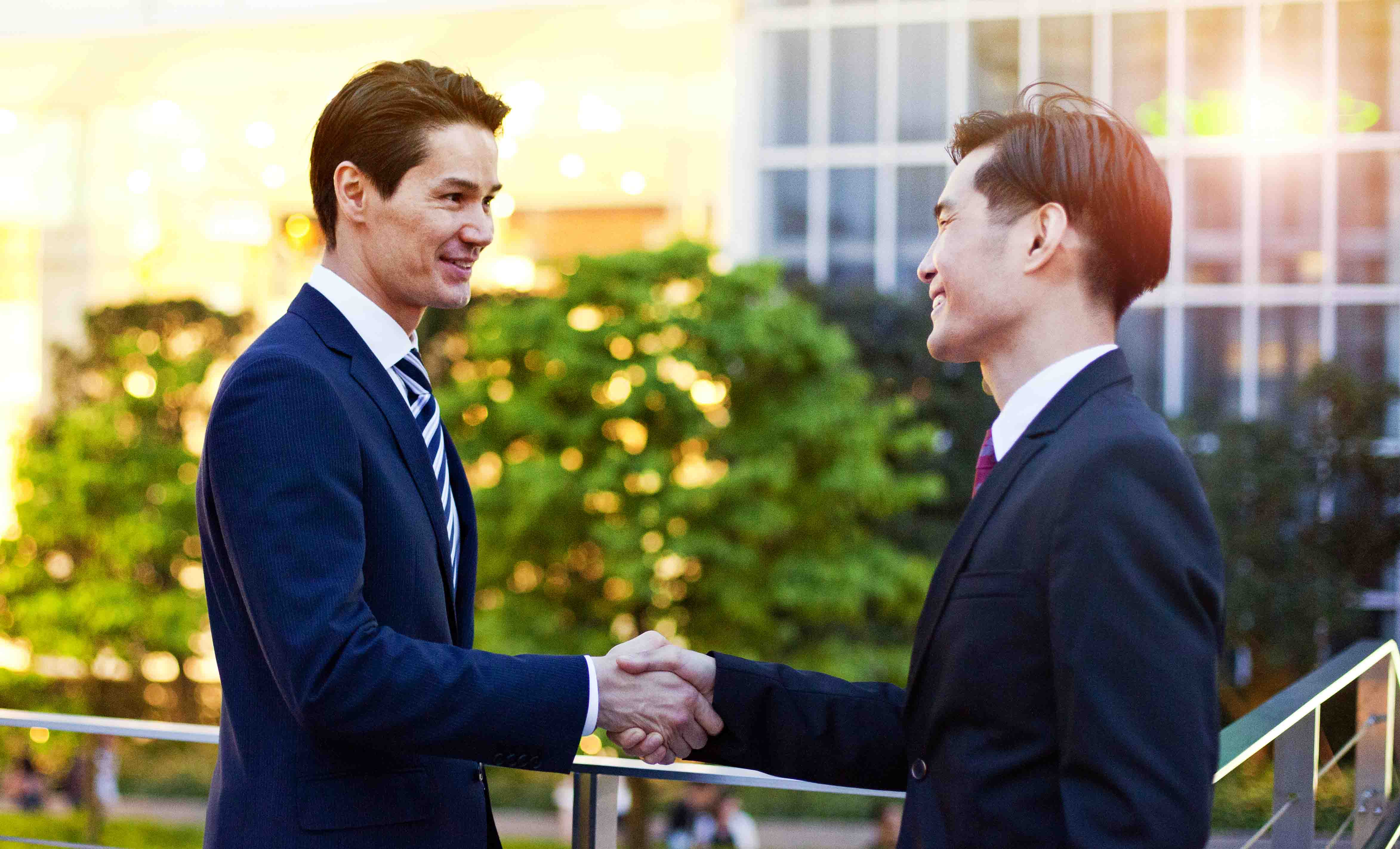 Two business men shaking hands with each other